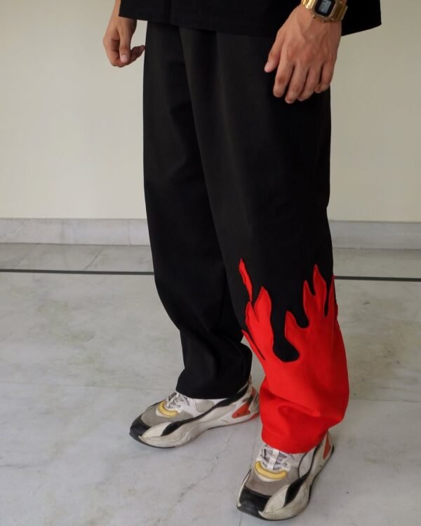 Close-up of flame graphic on The Drip Soul Red Fire Flame Kick Straight Baggy Track Pant highlighting stitching and vibrant print quality.