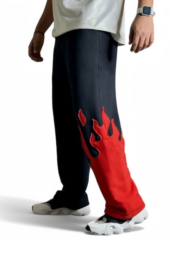 Model wearing The Drip Soul Red Fire Flame Kick Straight Baggy Track Pant – bold flame design with oversized streetwear fit.