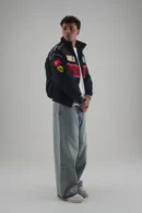 Side profile of man styling Ferrari F1 Vintage Racing Jacket with baggy jeans
