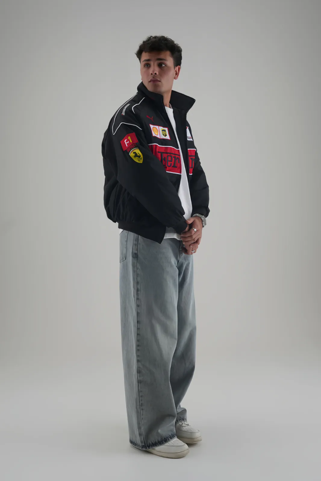 Side profile of man styling Ferrari F1 Vintage Racing Jacket with baggy jeans