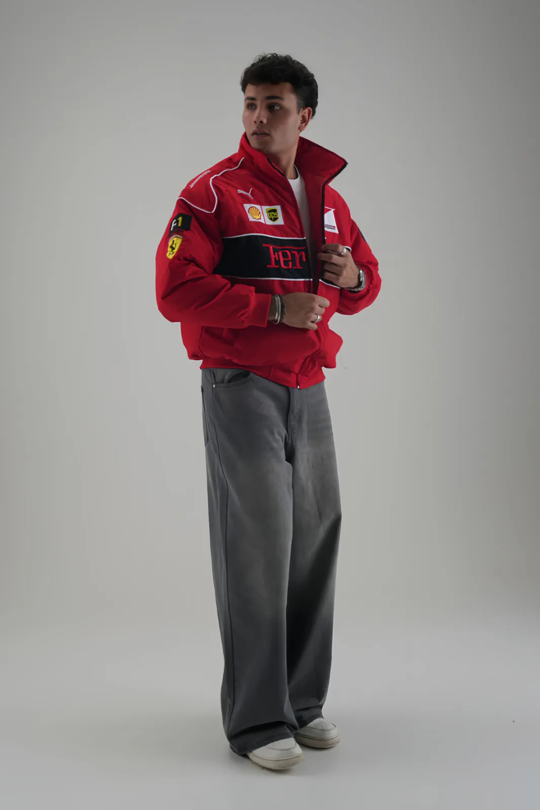 Man wearing THE DRIP SOUL Ferrari F1 Motorsport Track Racing Jacket and grey wide-leg jeans
