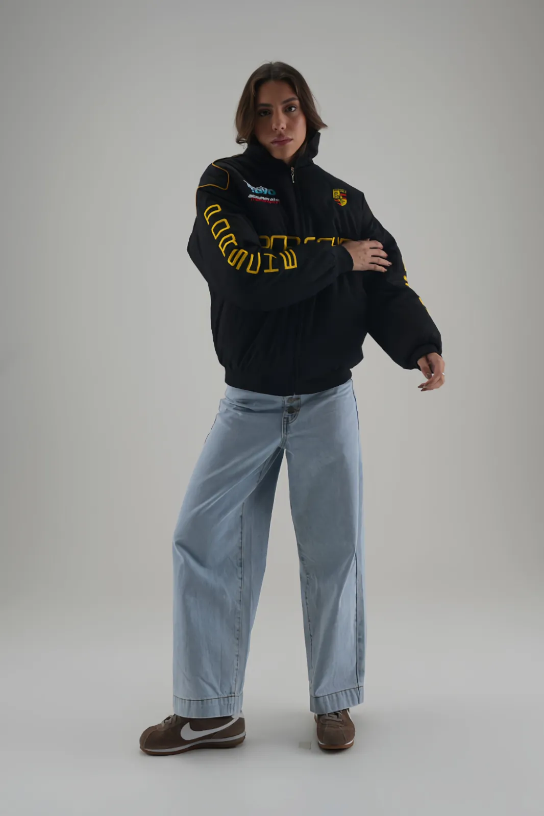 Unisex Porsche F1 Racing Bomber Puffer Jacket, styled with light wash wide-leg denim.